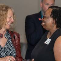 Provost Drake and Dr. Sherril Soman smile and laugh during a conversation